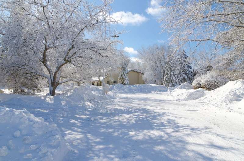 Residential Street Covered in Snow with Sunny Sky